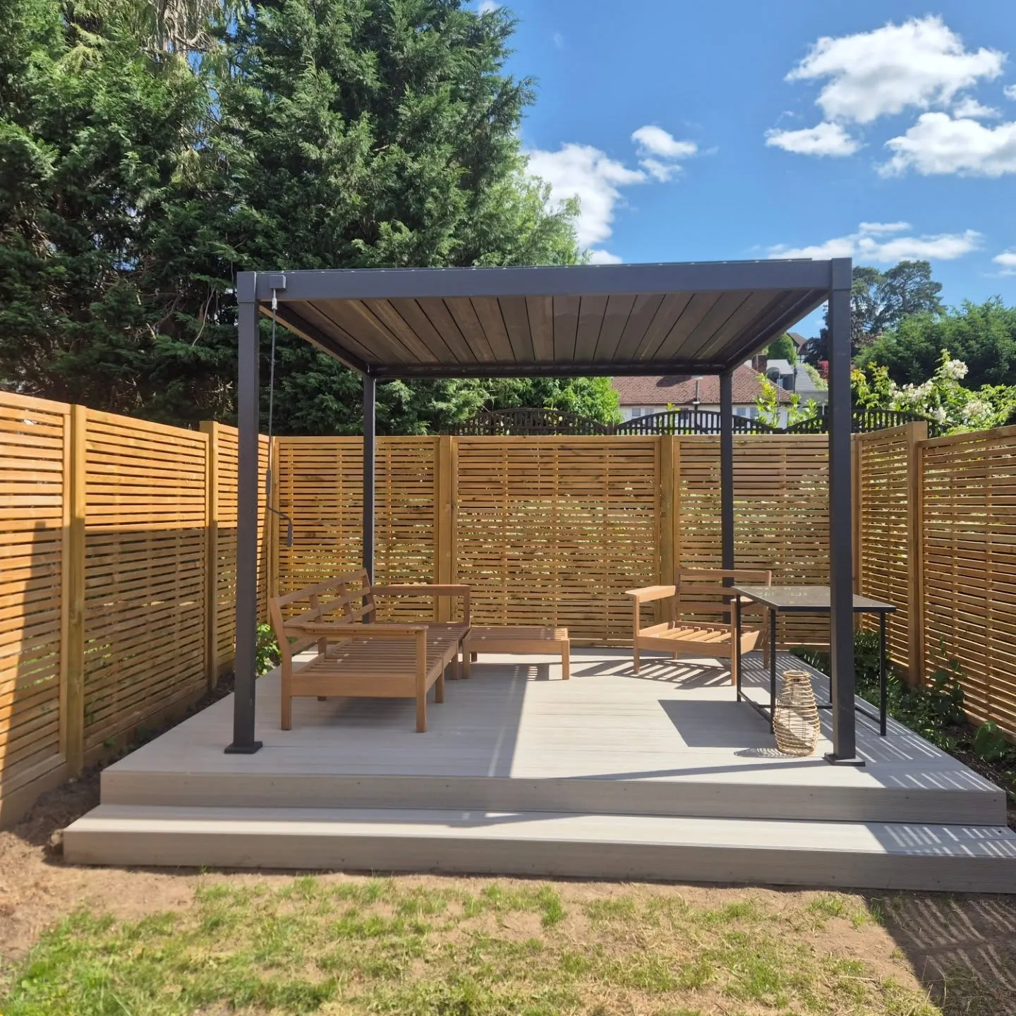 A patio with a wooden fence and a wooden bench.